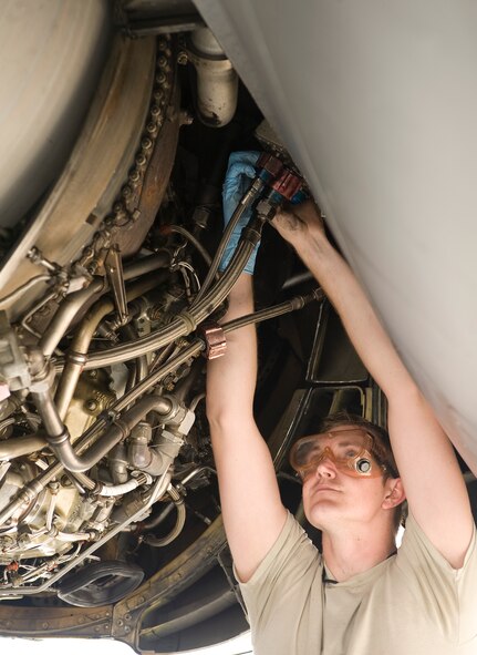 Senior Airman Christopher Green, 2nd Aircraft Maintenance Squadron crew chief, connects a hydraulic quick disconnect hose from an engine pump to a wing strut of a B-52H Stratofortress on Barksdale Air Force Base, La., March 28. Airmen from the 2 AMXS routinely inspect and repair the aircraft, checking wiring, fluid levels and any other parts that may have discrepancies.  (U.S. Air Force photo/Senior Airman Chad Warren)(RELEASED)