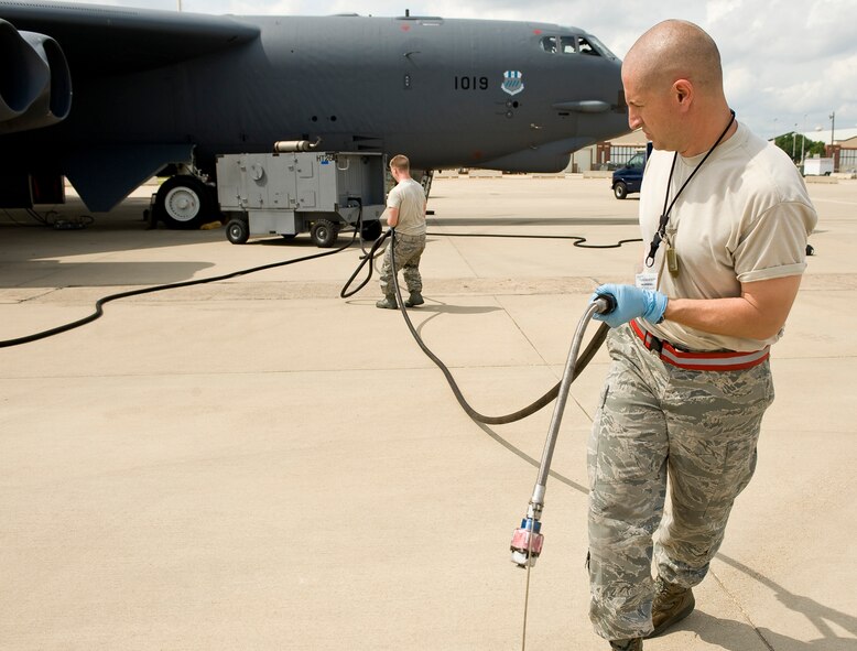 Tech. Sgt. Jason Gamble (right) and Staff Sgt. Mitchell Seitz, 2nd Aircraft Maintenance Squadron crew chiefs, drag hoses from a portable hydraulic test stand on Barksdale Air Force Base, La., March 28. Maintainers can perform upwards of 30 jobs during a routine pre-flight inspection of an aircraft. (U.S. Air Force photo/Senior Airman Chad Warren)(RELEASED)