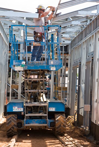 A construction worker attaches a piece of roofing to the new Child Development Center expansion on Barksdale Air Force Base, La., March 27. The new building will nearly double the CDC's capacity, helping to accommodate 142 additional Barksdale children. (U.S. Air Force photo/Senior Airman Chad Warren)(RELEASED)