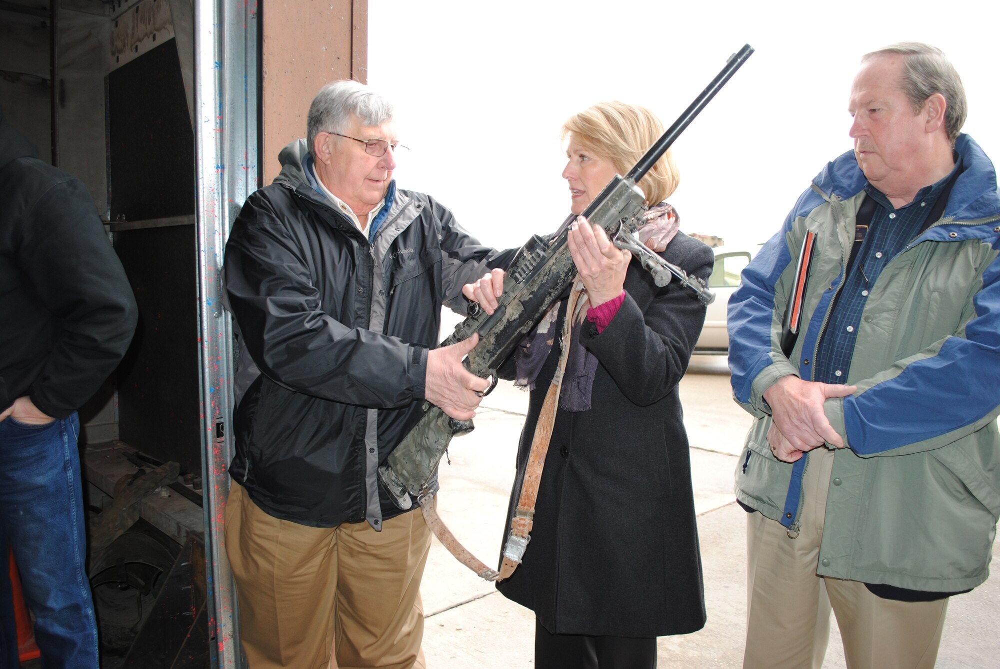 From left, Mike Murray, Lewis and Clark County commissioner, hands an M24 rifle to Pamela Parsons of MSU-Great Falls College of Technology, as Melvin Lehman, also of MSU-Great Falls, watches. Part of the Civic and Community Leader's tour was visitng TRF. (U.S. Air Force photo/Airman 1st Class Katrina Heikkinen