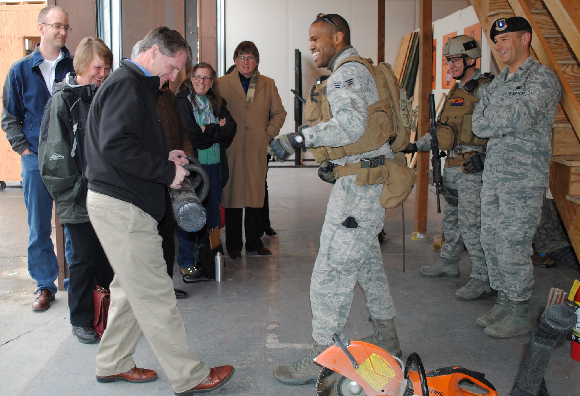 Senior Airman Jonathan Walker, 341st Security Forces Group, right, hands Andy Hunthausen, Lewis and Clark County commissioner, a ramming tool. Tactical response force members demonstrated how to use a quickie-saw, a broco torch and ramming tool as different methods to breach a building. More than 15 of Great Falls, Lewis and Clark and Cascade counties community members visited Malmstrom's missile procedures trainer, TRF, T-9 maintenance trainer, the 40th Helicopter Squadron and explosive ordnance disposal flight March 23. (U.S. Air Force photo/Airman 1st Class Katrina Heikkinen
