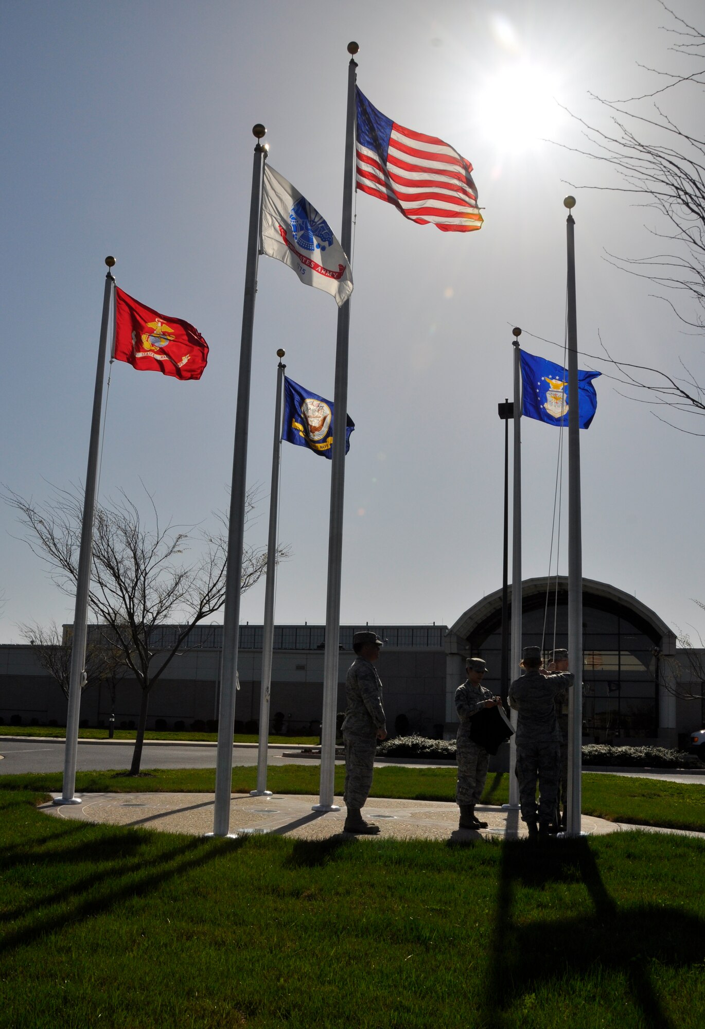 Airmen assigned to Air Force Mortuary Affairs Operations raise the flags in Memorial Flag Circle at Dover Air Force Base, Del.,  March 26, 2012. The flags had been taken down the day before, because a wind advisory forecasted winds greater than 35 mph. (U.S. Air Force photo/Lt. Col. Teresa Connor) 