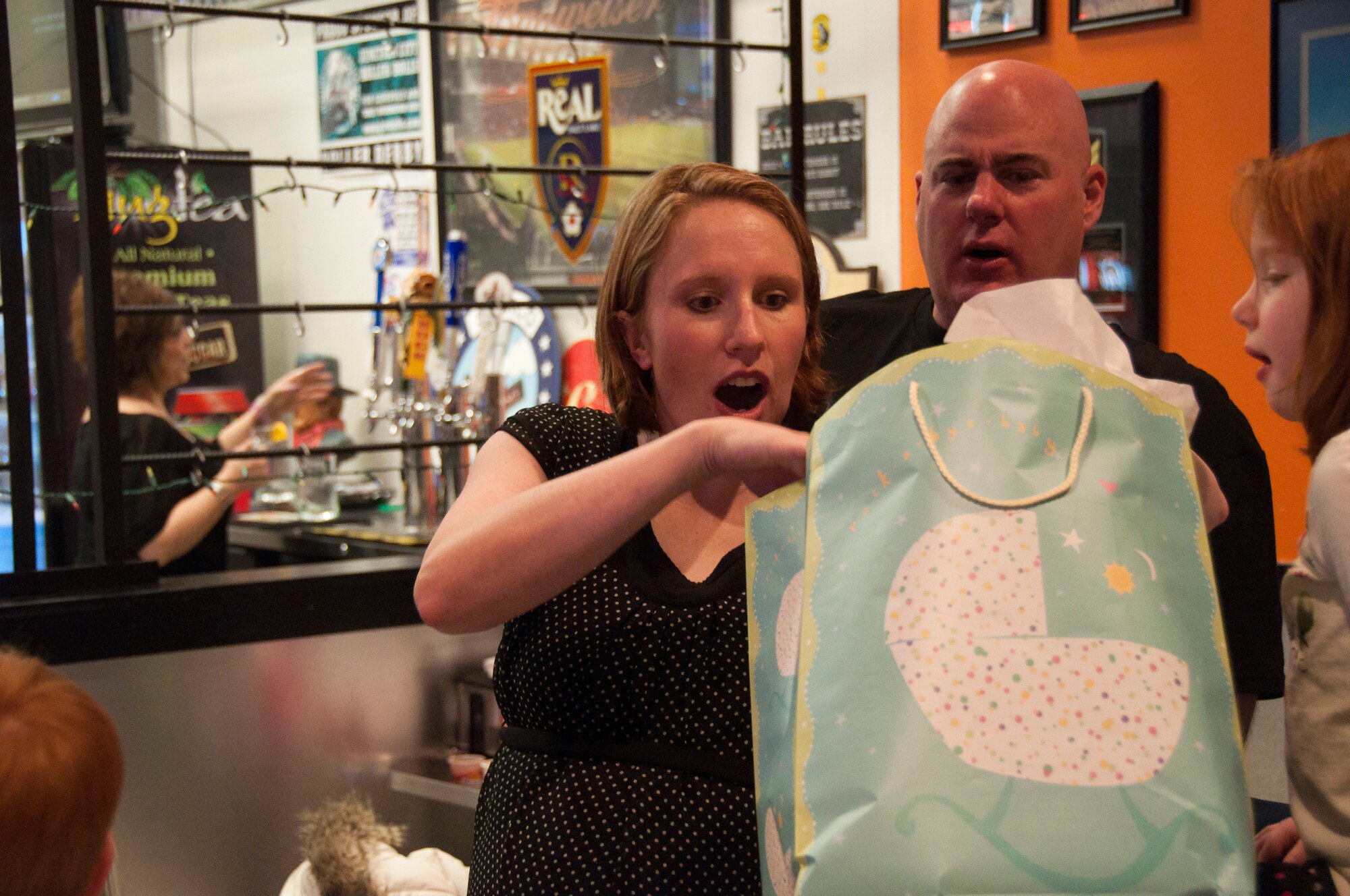 Master Sgt. Jenny Nicholson, 419th Force Support Squadron first sergeant, opens a gift from the wing. Angie Mood, wife of 419th Mission Support Group Commander Col. Charles Mood, donates homemade baby blankets to expecting mothers. (U.S. Air Force photo/Staff Sgt. Kyle Brasier)