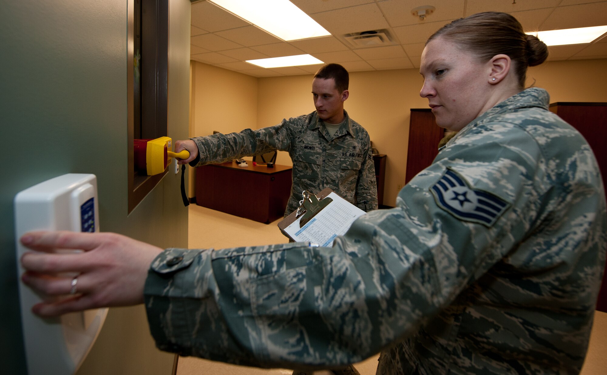Staff Sgt. Kathleen Couillard (right) and Airman 1st Class Dustin Monti, 28th Medical Operations Squadron bio-environmental engineering technicians, conduct a radiation scatter survey at the dental facility on Ellsworth Air Force Base, S.D., March 27, 2012. Bio-environmental engineering technicians help prevent health problems that could result from exposure to radiation by testing facilities around base for radiation emissions. (U.S. Air Force photo by Airman 1st Class Kate Thornton/Released)