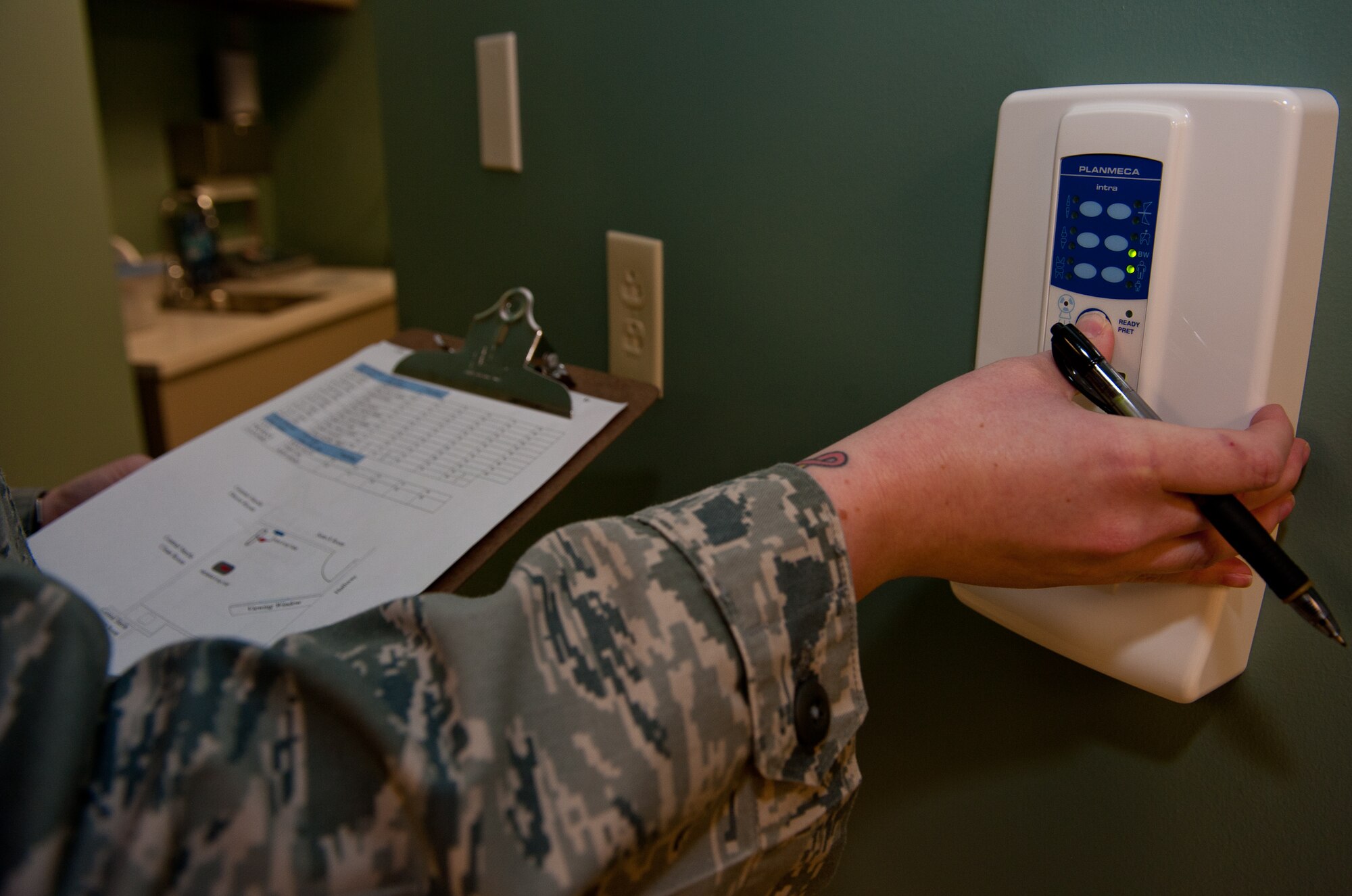 Staff Sgt. Kathleen Couillard, 28th Medical Operations Squadron bio-environmental engineering technician, starts an x-ray machine during a radiation scatter survey at the dental clinic on Ellsworth Air Force Base, S.D., March 27, 2012. Once the x-ray machine starts emitting radiation, the ion chamber survey meters will pick up a reading to provide an accurate measurement of radiation levels present within the facility. (U.S. Air Force photo by Airman 1st Class Kate Thornton/Released)