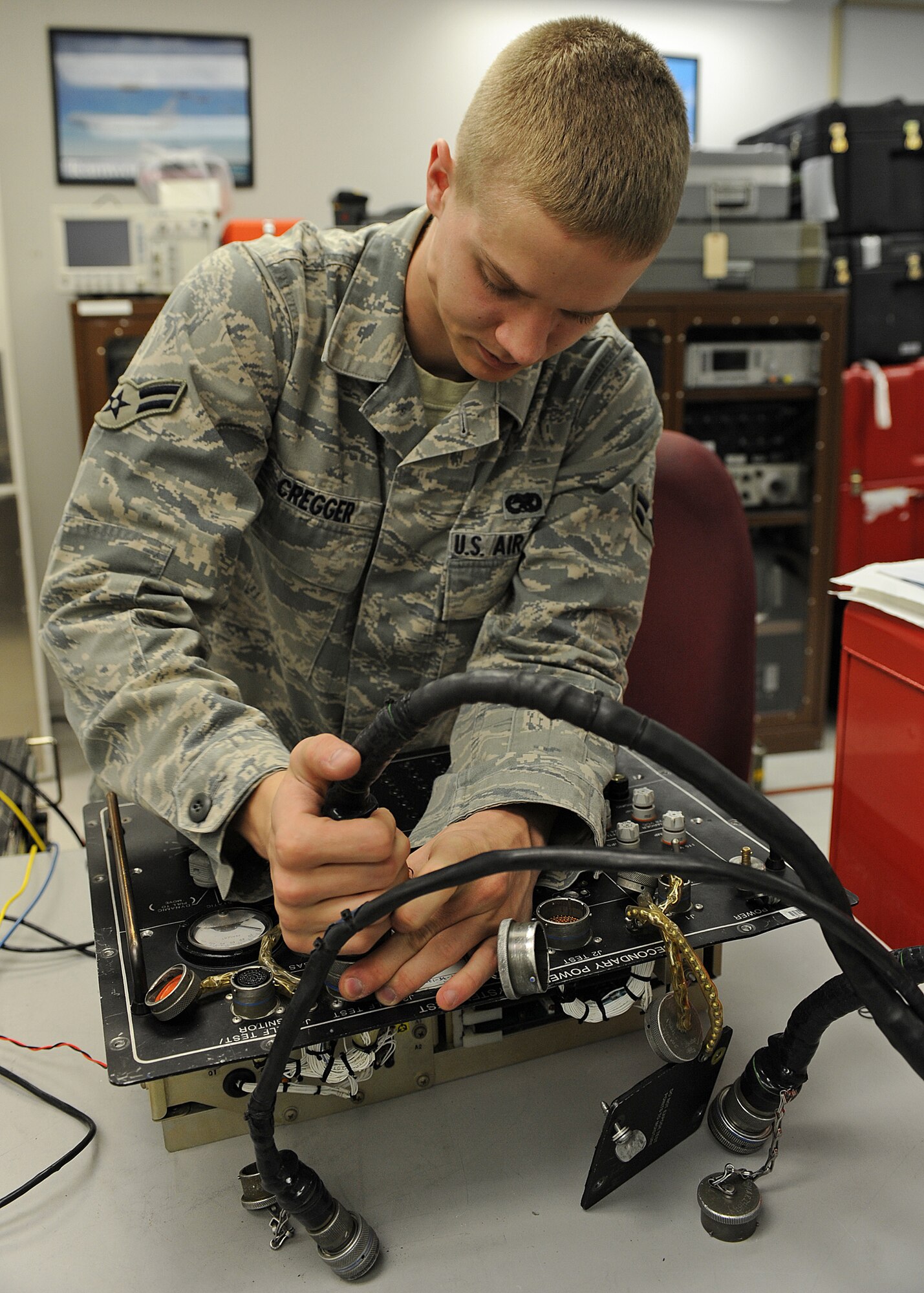 U.S. Air Force Airman 1st Class Jeffery Cregger pulls a W-4 power harnest from a secondary power system tester in the precision measurement equipment laboratory on Seymour Johnson Air Force Base, N.C., March 28, 2012. Air crew members use the tester to troubleshoot primary power failures on the F-15E Strike Eagle as well as activate the secondary power system. Cregger, 4th Component Maintenance Squadron test measurement diagnostic equipment technician, is from Frederick, Md. (U.S. Air Force photo/Airman 1st Class John Nieves Camacho/Released)