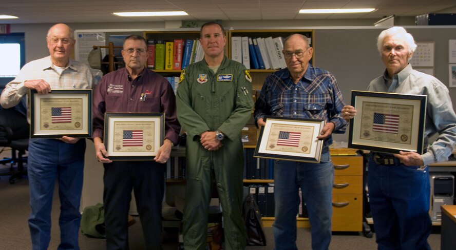 Snyder residents, from left to right, Max Von Roeder, Roger Sullenger, Rex Glass and Peewee Graves pose with Col. Mark Bennett, 7th Operations Group commander, after receiving a certificate of recognition March 27, 2012, at the Snyder Electronic Scoring Site in Snyder, Texas. They were recognized by Dyess leadership for allowing portions of their land to be used in support of aircraft defensive tactics training. (U.S. Air Force photo by Airman 1st Class Charles V. Rivezzo/Released)