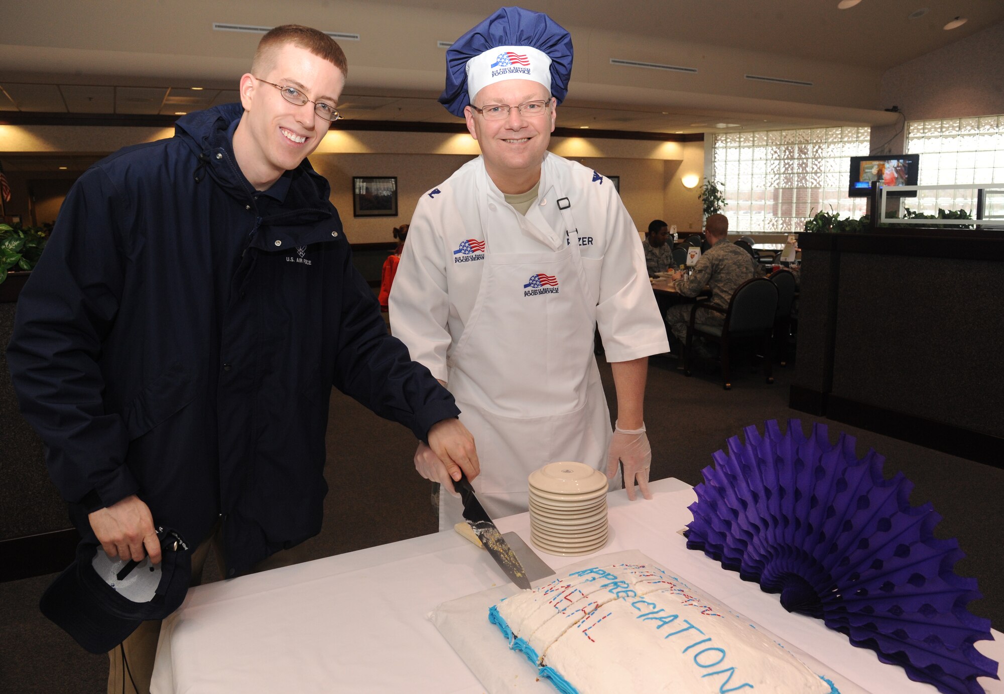 Airman 1st Class Charles Coushaine, left, 319th Force Support Squadron, and Col. Scott Rizer, 319th Air Base Wing vice commander, cut the cake during an Airmen Appreciation Dinner on March 28, 2012, on Grand Forks Air Force Base, N.D.  The dinner – which included steak, lobster and chicken cordon bleu - was a chance for the leadership to thank the Airmen for all they do.  (U.S. Air Force photo by Airman 1st Class Xavier Navarro)