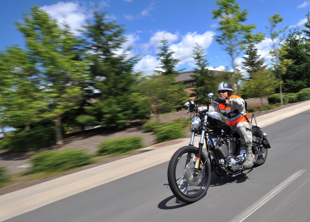 Staff Sgt. Alvin Llamas, 92 Civil Engineer Squadron water and fuels maintenance, rides his motorcycle on base July 15, 2011. It is mandatory for Airmen to wear full-fingered gloves for all military members, but it is also an effective protective measure to keep the rider’s hands safe in case of an accident. (U.S. Air Force photo/Staff Sgt. Michael Means)
