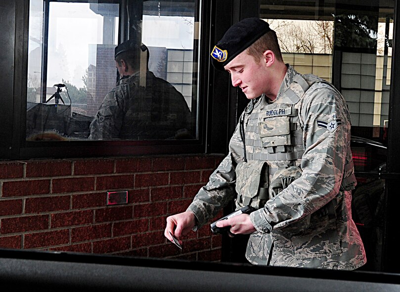 Airman 1st Class Robert Rudolph, 92nd Security Forces Squadron, uses the Defense Biometric Identification System to scan DOD identification cards at the main entry control point Tuesday. DBIDS is a Department of Defense identity authentication and force protection tool used to scan bar codes and biometrics on DOD ID cards and Common Access Cards. (U.S. Air Force photos by Airman 1st Class Taylor Curry)