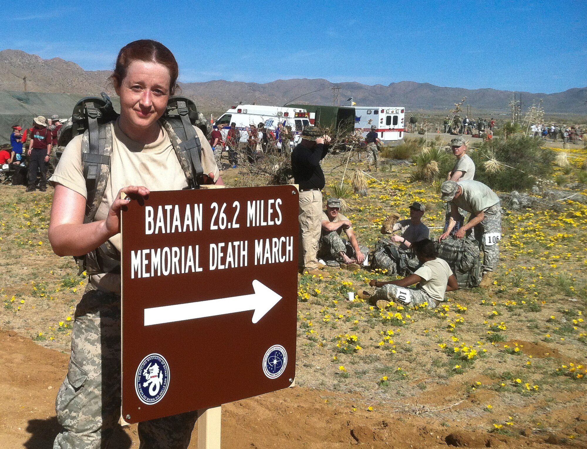 Second Lieutenant Bonnie Mattingly stands behind the sign that guides marchers along the Bataan Memorial Death March route March 25 at White Sands Missile Range in White Sands, N.M. Mattingly was determined to do something big following her commission in November and used the march to both celebrate her commission and memorialize the historic World War II Bataan Death March. (U.S. Army courtesy photo/Released)
