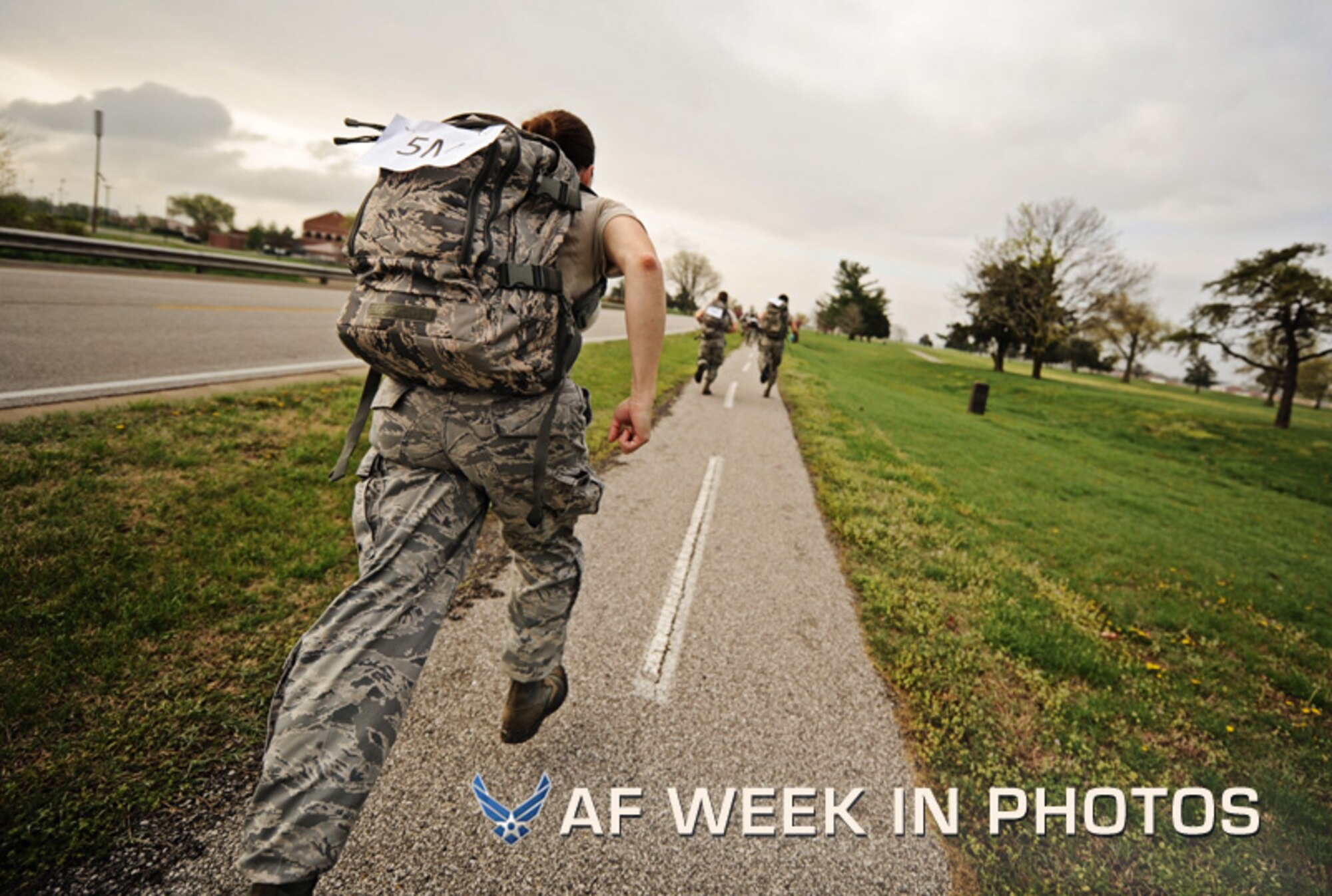 With 20 pounds strapped to her back, an Airman sprints to catch up to her teammates during the Bataan Memorial Death March at Scott Air Force Base, Ill., March 25, 2012. Personnel assigned to Scott AFB participated in the base’s inaugural Bataan Memorial Death March in honor of the thousands who lost their lives during the actual march during World War II. More than 50 teams and 250 people marched 12.6 miles to complete the course. (U.S. Air Force photo/Staff Sgt. Ryan Crane)