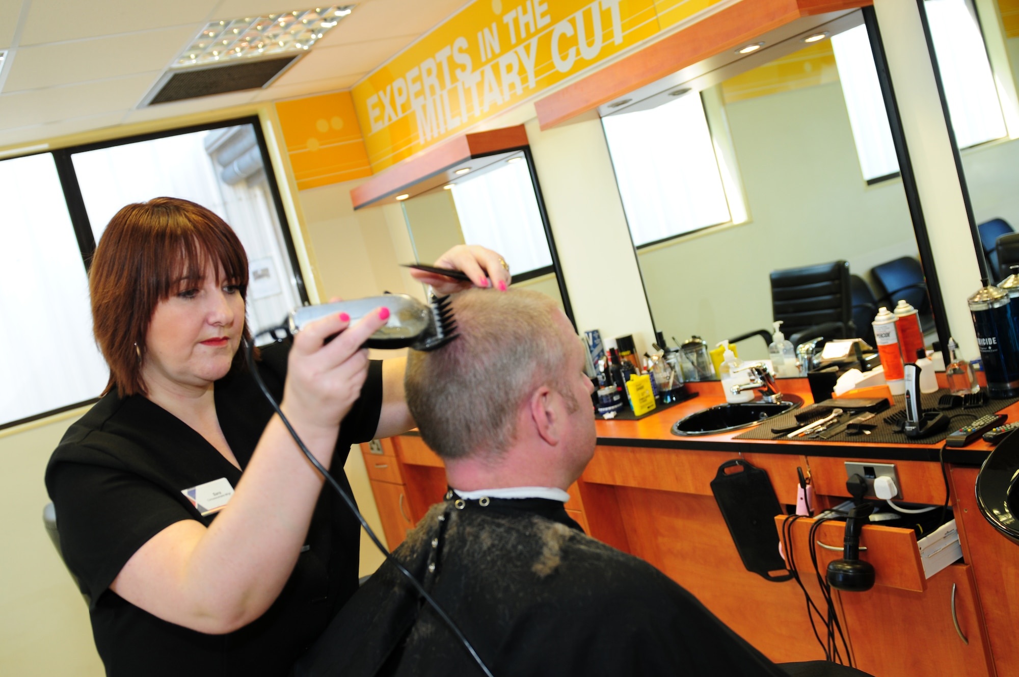 ROYAL AIR FORCE LAKENHEATH, England – Sara Snazell, Flightline Barber Shop co-owner barber, clips Tech. Sgt.  Kristopher Mckethen, 48th Equipment Maintenance Squadron swing shift supervisor, March 28, 2012. The Flightline Barber Shop is open from 9 a.m. to 6:00 p.m. Monday through Friday. (U.S. Air Force photo by Airman 1st Class Cory D. Payne)