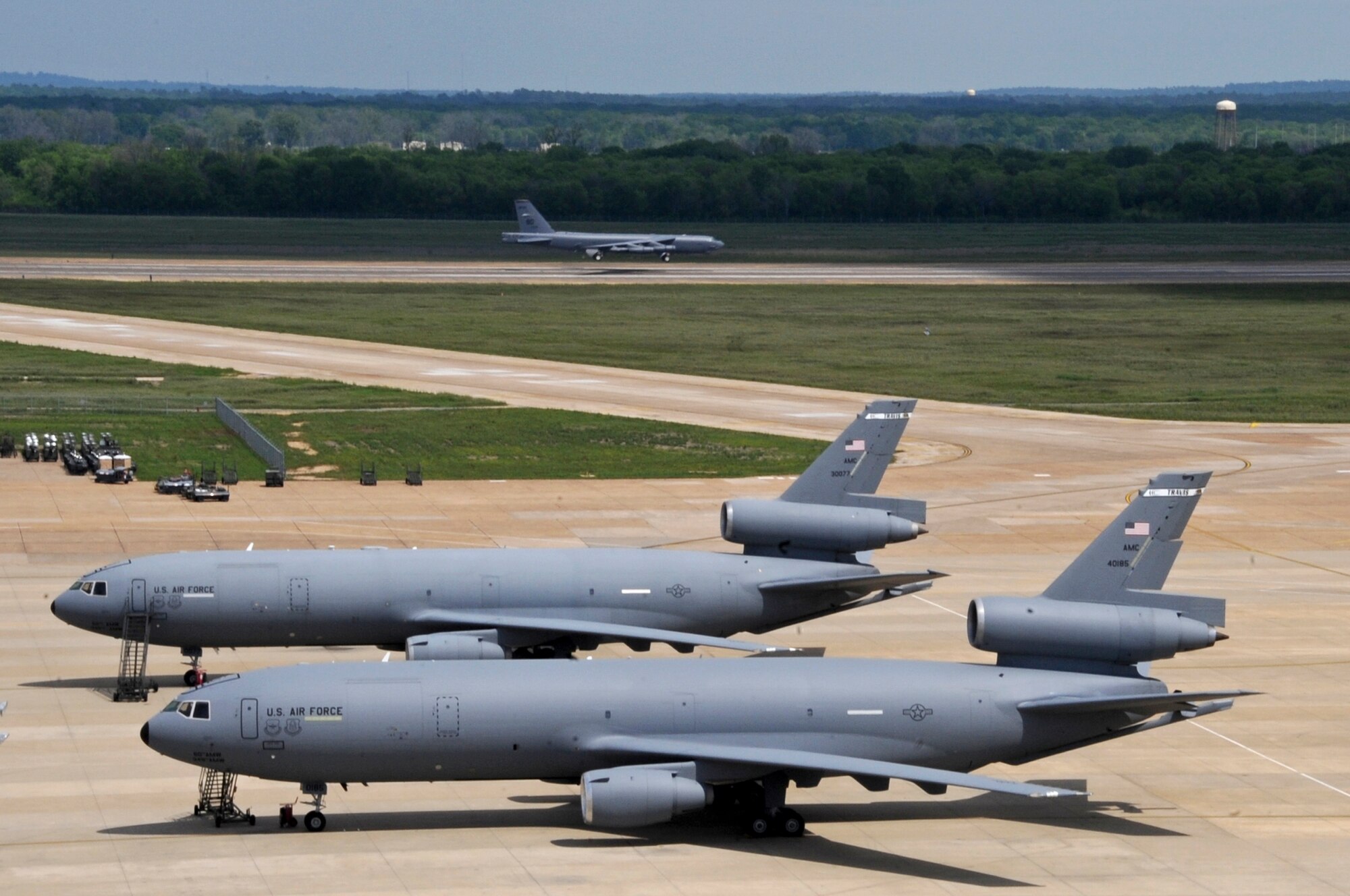 A Barksdale B-52H Stratofortress lands opposite KC-10 Extenders on Barksdale Air Force Base, La., March 28. KC-10s are primarily for refueling, however the aircraft is capable of carrying support personnel and equipment. The KC-10s are visiting from Travis AFB, Calif. and McGuire AFB, N.J., to practice in-flight refueling with larger aircraft. (U.S. Air Force photo/Airman 1st Class Micaiah Anthony)(RELEASED) 
