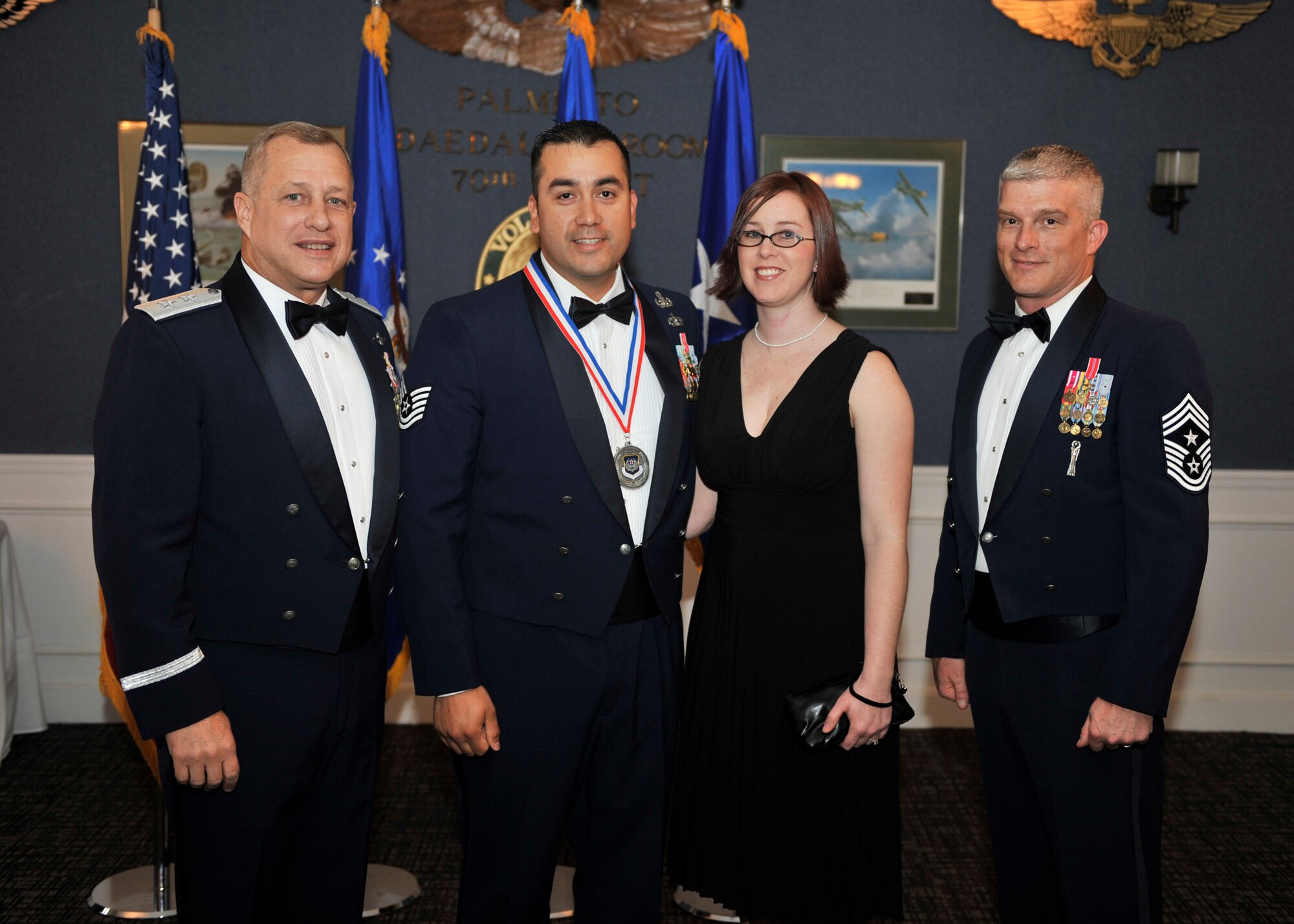 Maj. Gen. Lawrence Wells, 9th Air Force commander, left, and Chief 
Master Sgt. Robert Brooks, 9th Air Force command chief, right, stand with 
Tech. Sgt. Alejandro Rodriguez and his wife Amanda, after presenting Sergeant 
Rodriguez with a medallion March 21 for winning Noncommissioned Officer of the 
Year. Sergeant Rodriguez is a member of the 20th Civil Engineer Squadron 
Explosive Ordnance Disposal Unit, Shaw Air Force Base, S.C.
