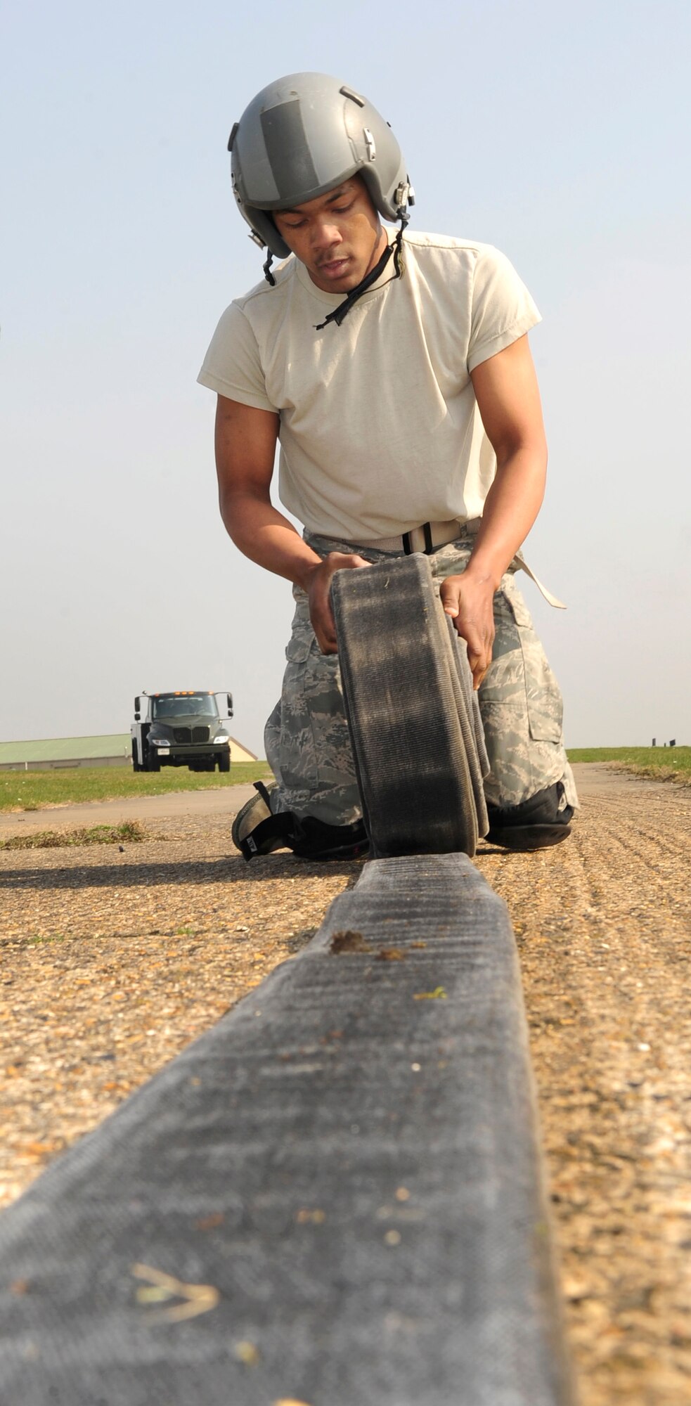 RAF MILDENHALL, England – Airman 1st Class Marcus Green, 100th Logistics Readiness Squadron fuels apprentice, rolls a 3-inch fuels hose during the first challenge of the Forward Area Refueling Point qualification course here March 23, 2012. After rolling the 95-pound hose, the member runs it back to the starting point to finish the challenge course. (U.S. Air Force photo/Senior Airman Ethan Morgan)