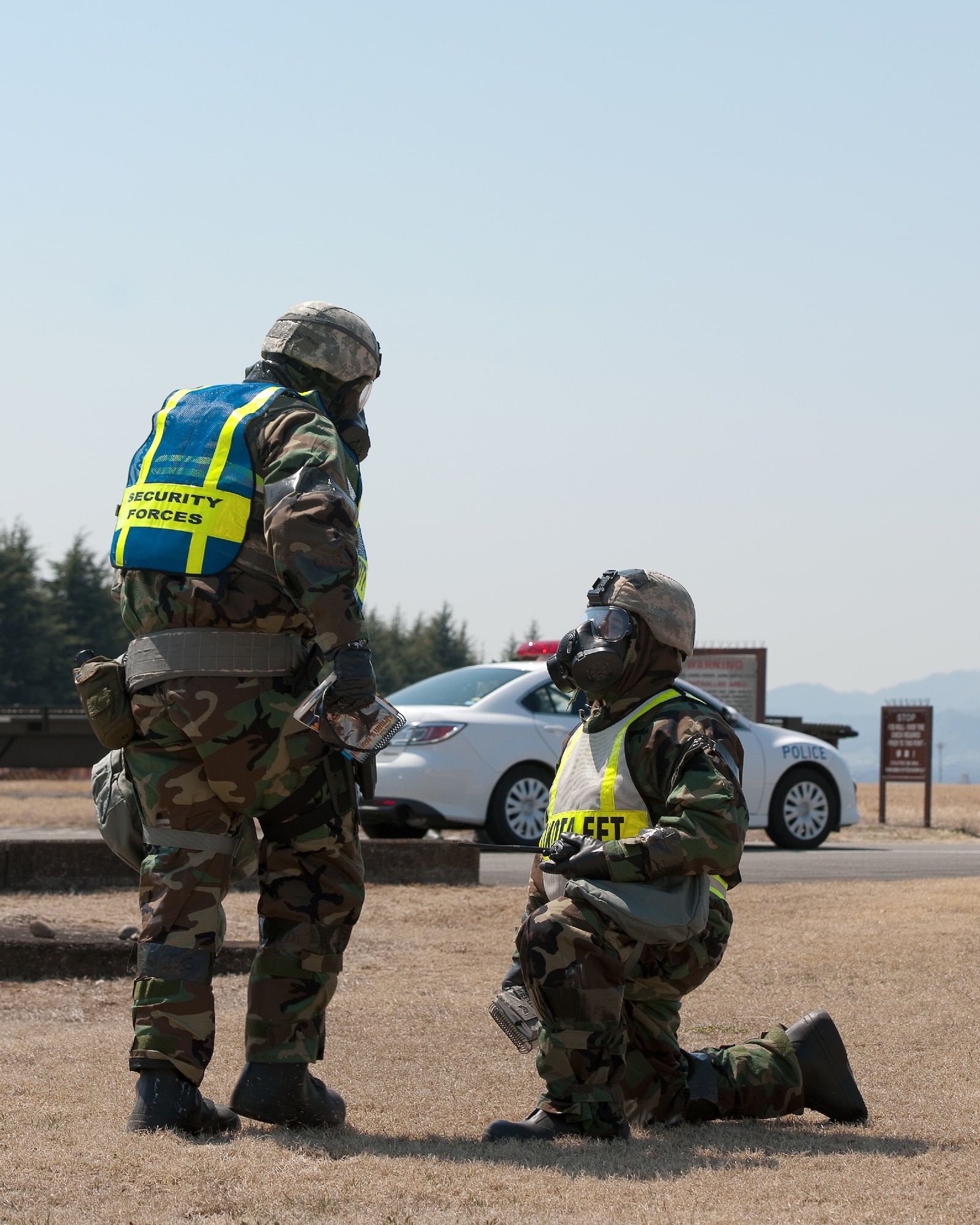 YOKOTA AIR BASE, Japan -- Tech. Sgt. Alberto Verastegui (right), 374th Security Forces Squadron exercise evaluation team member, inspects the gas mask of Senior Airman Justin Newman (left), 374th Security Forces Squadron patrolman, during a base exercise at Yokota Air Base, Japan, March 27, 2012.  Airmen at Yokota participate in exercises to maintain their operational readiness capabilities. (U.S. Air Force photo/Osakabe Yasuo)