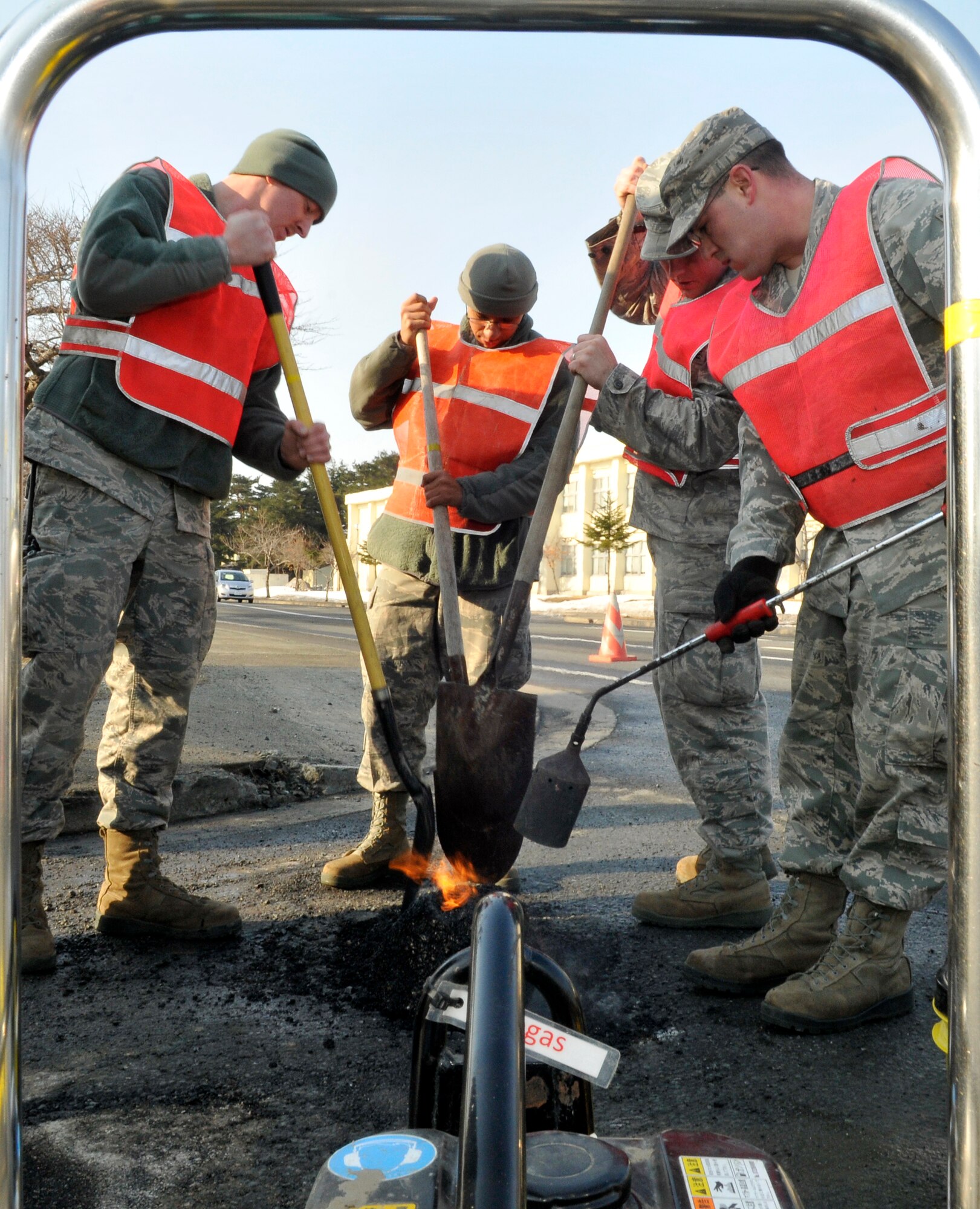 U.S. Air Force Airmen from the 35th Civil Engineering Squadron heat an instant road repair compound into a pothole at Misawa Air Base, Japan, March 29, 2012.  CES Airmen will fill approximately 100 potholes this year using more than 350 buckets of repair compound. (U.S. Air Force photo by Tech. Sgt. Phillip Butterfield/Released)

