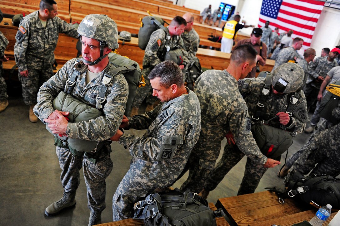 Air Force Lt. Col. Matthew Foley, left foreground, gears up before jumping onto drop zone Normandy on Fort Bragg, N.C., March 22, 2012.