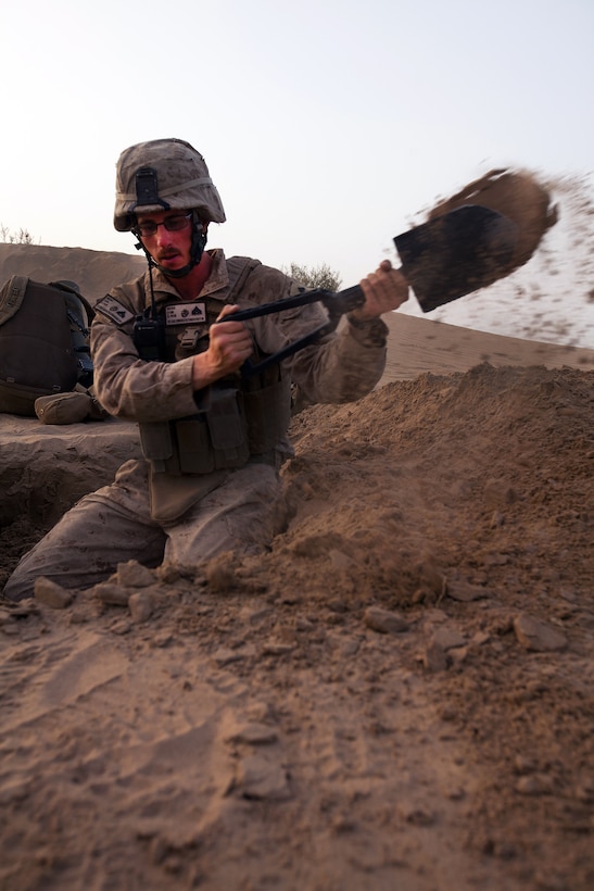 U.S. Marine Corps Cpl. John Berg digs a fighting hole during an overnight post near Khan Neshin, Afghanistan, March 23, 2012. Berg is a team leader assigned to Alpha Company, 1st Light Armored Reconnaissance Battalion.