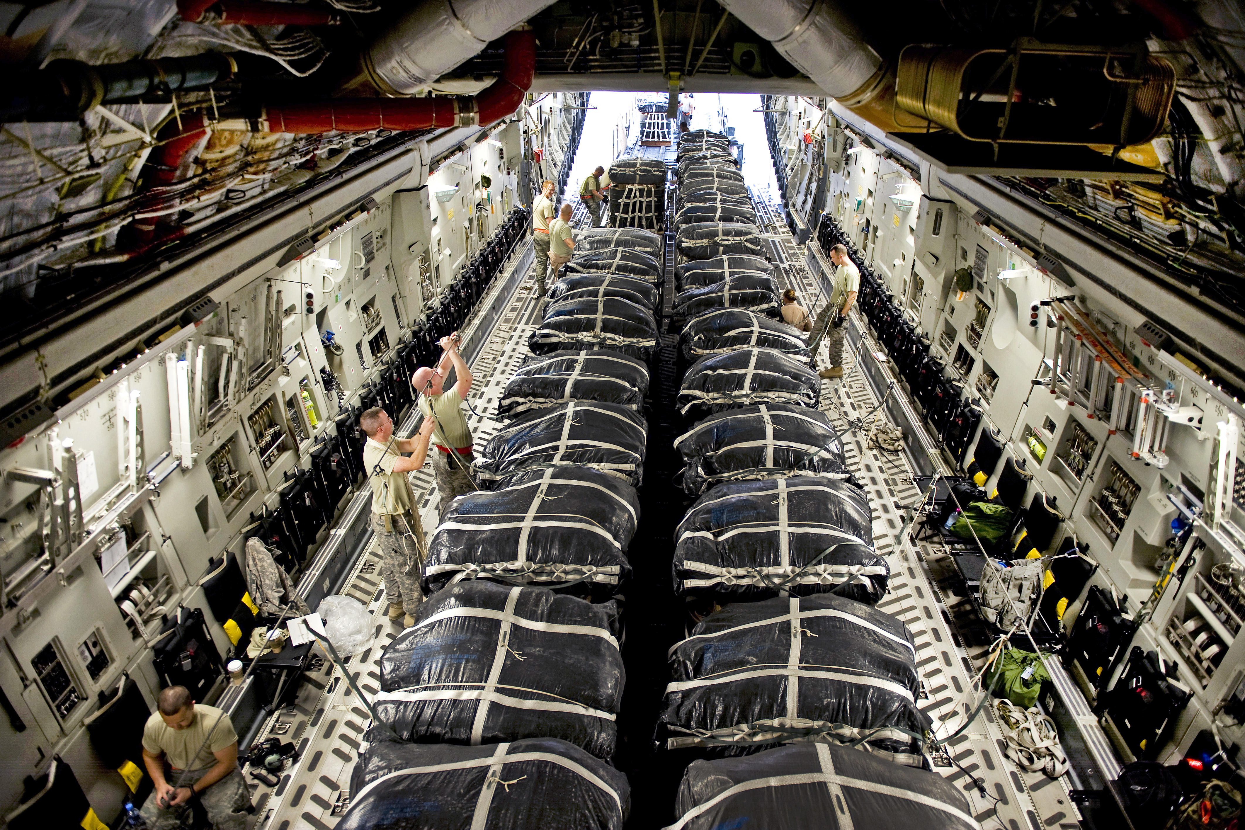 U.S. Air Force airmen and soldiers prepare bundles of jet fuel for an  airdrop mission on