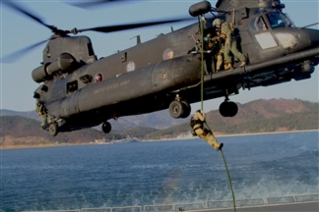 A U.S. Navy SEAL with Naval Special Warfare Group 1 fast ropes from an Army MH-47 Chinook helicopter onto the aft deck of the fast combat support ship ROKS Hwacheon (AOE 59) in Jinhae Harbor, South Korea, during Foal Eagle 2012 on March 20, 2012.  Foal Eagle is a combined U.S.-South Korea field training exercise held annually in South Korea to ensure the operational readiness of air, space and cyberspace operations in the Korean theater of operations.  
