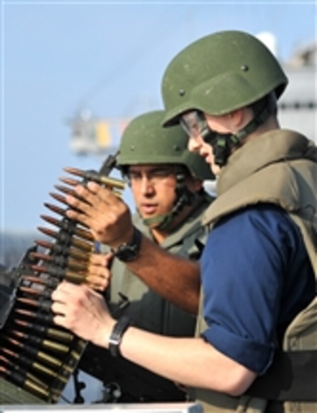 U.S. Navy Petty Officer 1st Class Eduardo Soto (left) instructs Seaman Tyler Bishop on firing a .50 caliber machine gun during a live-fire exercise aboard the U.S. 7th Fleet command ship USS Blue Ridge (LCC 19) in the South China Sea on March 28, 2012.  