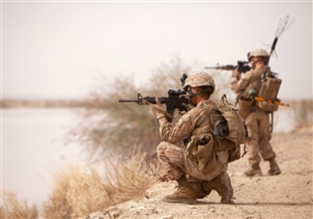 U.S. Marine Corps Lance Cpl. Fabian Aguilar, an assistant gunner with Weapons Platoon, 1st Light Armored Reconnaissance Battalion and Lance Cpl. Michael Fitch II, a point man with Weapons Platoon., Alpha Company, 1st Light Armored Reconnaissance, sight in while posting security during a patrol near the Helmand River, Helmand province, Afghanistan, on March 24, 2012.  
