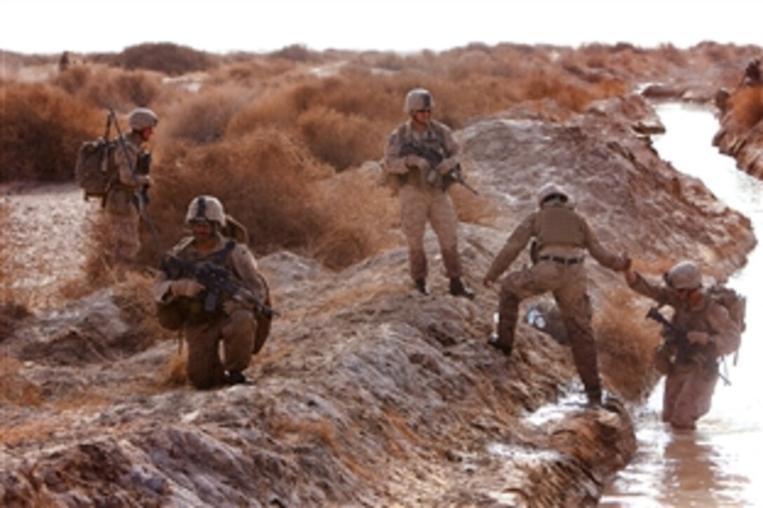 U.S. Marines cross a canal as they head to an overnight post in Afghanistan, March 23, 2012.  The Marines are assigned to the Weapons Platoon, Alpha Company, 1st Light Armored Reconnaissance Battalion.