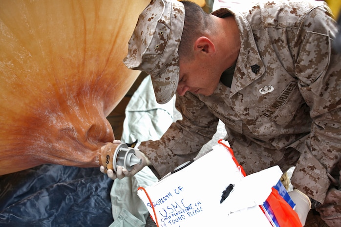 Sgt. Emmanuel T. Martinez, radio supervisor, Command Element, 15th Marine Expeditionary Unit, connects a helium balloon to the transmitter of a Combat SkySat communication system at Camp Pendleton, Calif., March 29. The SkySat system is used to retransmit UHF signals to increases the range of communication up to 600 miles in diameter and expands the capabilities of the Marine Air Ground Task Force.