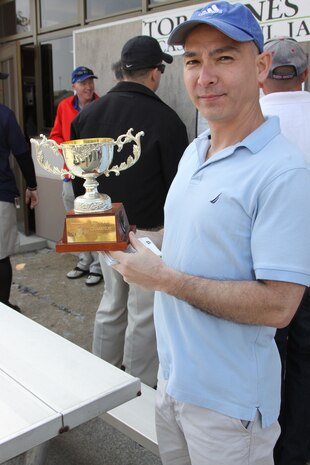 Charles A. Redden shows off the Torii Pines Championship Trophy after claiming victory during the final Torii Pines golf tournament held at the Torii Pines Golf Course here March 30. The tournament ended with Marine Aviation Logistics Squadron 12 taking the win with a score of 15 and a half to 14 and a half.