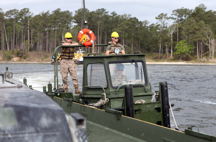 Marines with Bridge Company, 8th Engineer Support Battalion, 2nd Marine Logistics Group steer a MKIII Bridge Erection Boat that pushes a raft across the New River during an operation aboard Camp Lejeune, N.C., March 30, 2012. The Marines transported 15 vehicles and 48 passengers across the river via the raft.