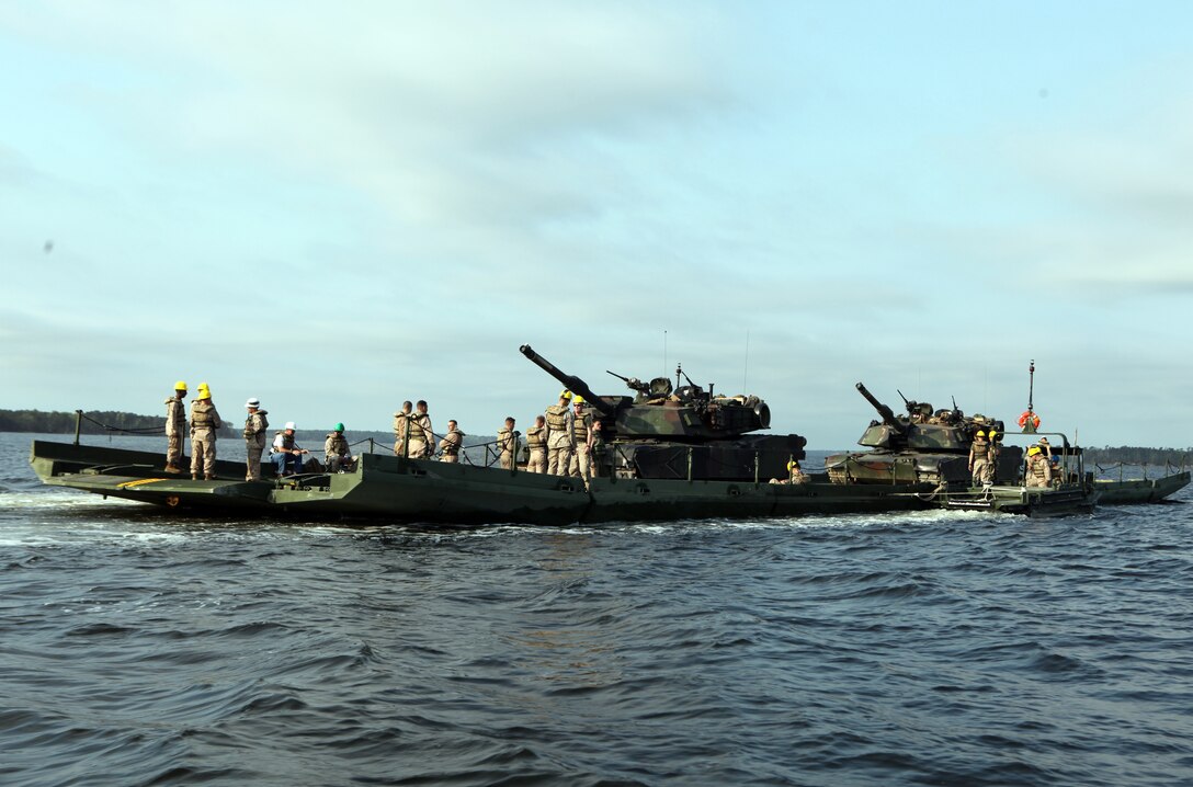 Marines with 8th Engineer Support Battalion, 2nd Marine Logistics Group and Marines with 2nd Tank Battalion, 2nd Marine Division ride on a raft across the New River during an operation aboard Camp Lejeune, N.C., March 30, 2012. The Marines with Bridge Company, 8th ESB transported 15 tanks and 48 passengers for 2nd Tank Bn.