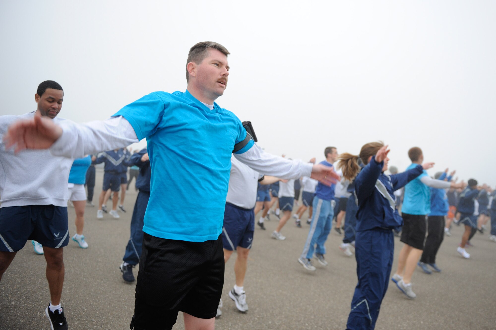 VANDENBERG AIR FORCE BASE, Calif. -- Master Sgt. Scott Munden, the 30th Force Support Squadron career assistance advisor, performs jumping jacks to warm up prior to the monthly Fit-to-Fight Run here Friday, March 20, 2012. Runners were encouraged to wear blue and teal T-shirts, representing Child Abuse Awareness Month and Sexual Assault Awareness Month respectively. Various events will be held for both causes throughout the month, contact the sexual assault response coordinator and family advocacy office for more details. (U.S. Air Force photo/Staff Sgt. Levi Riendeau)
