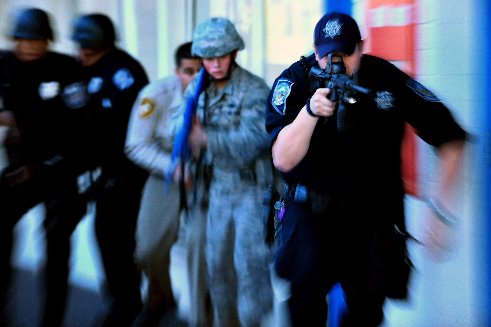 A law enforcement team consisting of two North Las Vegas Police Department police officers, one Airman from 99th Security Forces Squadron, one Nevada Highway Patrol officer and one Las Vegas Metro Police Department officer, move quickly as two simulated gunman fire upon students  at Lomie Heard Elementary School, March 28, 2012 during a Multi Assault Counter Terrorism Action Capabilities exercise at Nellis Air Force Base, Nev. The scenario prepared participants to respond to real-word active shooter events. (U.S. Air Force photo by Staff Sgt. William P.Coleman)
  

