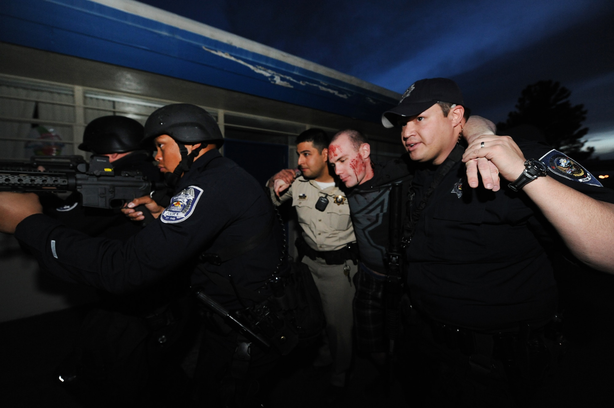 A law enforcement team consisting of two North Las Vegas Police Department police officers, one Airman from 99th Security Forces Squadron, one Nevada Highway Patrol officer and one Las Vegas Metro Police Department officer extract a simulated casualty from Lomie Heard Elementary School, March 28, 2012, during a Multi Assault Counter Terrorism Action Capabilities exercise at Nellis Air Force Base, Nev. The scenario was based on historical active shooter incidents. (U.S. Air Force photo by Staff Sgt. William P.Coleman)
  

