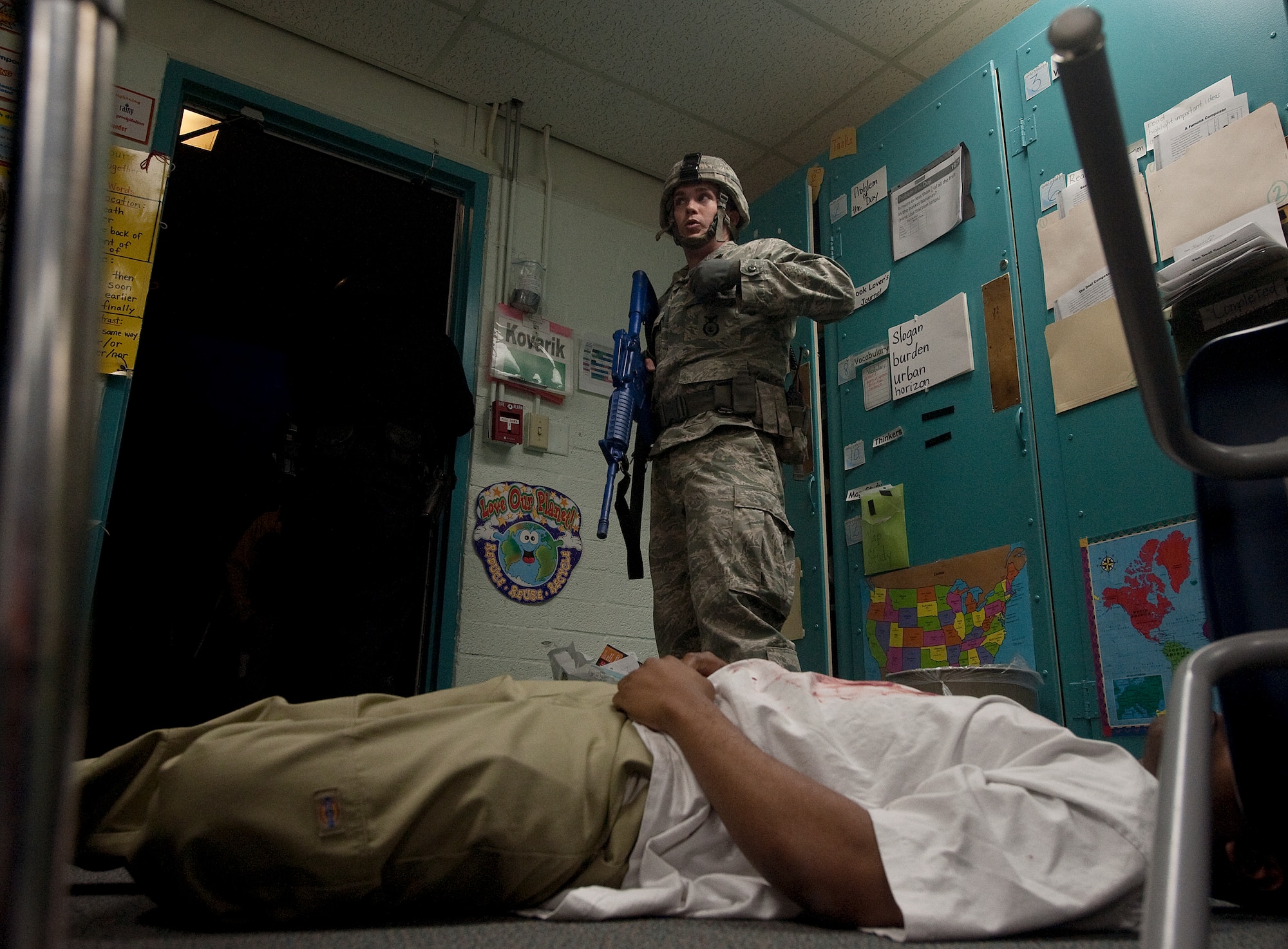 U.S. Air Force Senior Airman Alan Eaby, 99th Security Forces Squadron patrolman, reports information after finding a simulated casualty during the Multi Assault Counter Terrorism Action Capabilities training located at Lomie Heard Elementary School March 28, 2012, at Nellis Air Force Base, Nev. Members of the 99th Medical Group assisted with the exercise by applying moulage to 25 people role-playing as casualties. (U.S. Air Force photo by Staff Sgt. Christopher Hubenthal) 