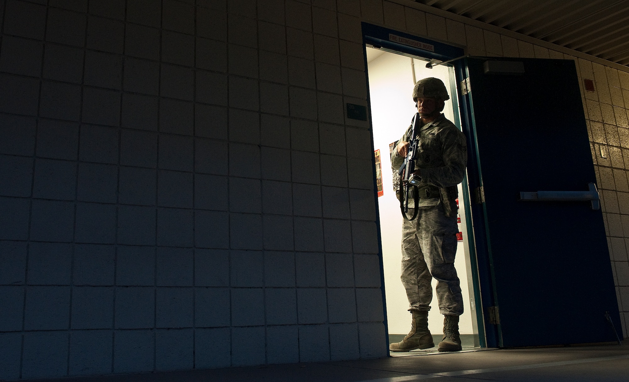U.S. Air Force Senior Airman Joshua Carbone, 99th Security Forces Squadron patrolman, scans an area outside of a classroom during the Multi Assault Counter Terrorism Action Capabilities training located at Lomie Heard Elementary School March 28, 2012, at Nellis Air Force Base, Nev. The exercise focused on response, tactics, terminating threats, evacuation of personnel, containment, and securing a crime scene for investigation. (U.S. Air Force photo by Staff Sgt. Christopher Hubenthal) 