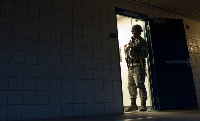 U.S. Air Force Senior Airman Joshua Carbone, 99th Security Forces Squadron patrolman, scans an area outside of a classroom during the Multi Assault Counter Terrorism Action Capabilities training located at Lomie Heard Elementary School March 28, 2012, at Nellis Air Force Base, Nev. The exercise focused on response, tactics, terminating threats, evacuation of personnel, containment, and securing a crime scene for investigation. (U.S. Air Force photo by Staff Sgt. Christopher Hubenthal) 