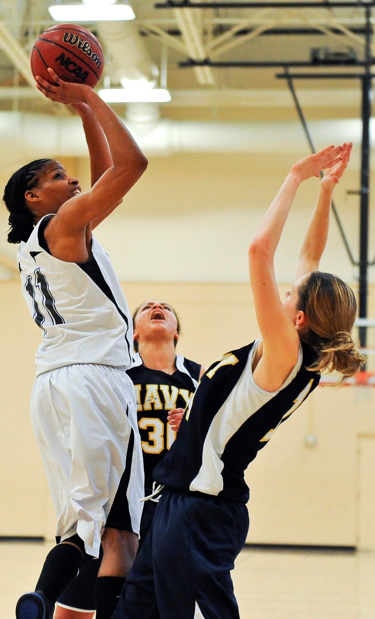 Senior Airman Willamina Folks, Macdill AFB, Fla., goes up for a shot over
the head of Lt. j.g. Jen Schumacher of the Naval Nuclear Power Training
Command in Whitney Point, NY.  On the sixth day of the Women's Armed Forces
Basketball Championship, the Air Force maintained a ten-point lead against
the Navy during their final match up.  The Air Force was up 27-17 at the
half, and maintained their lead throughout the game, winning with 60 points
against the Navy's 49. 
