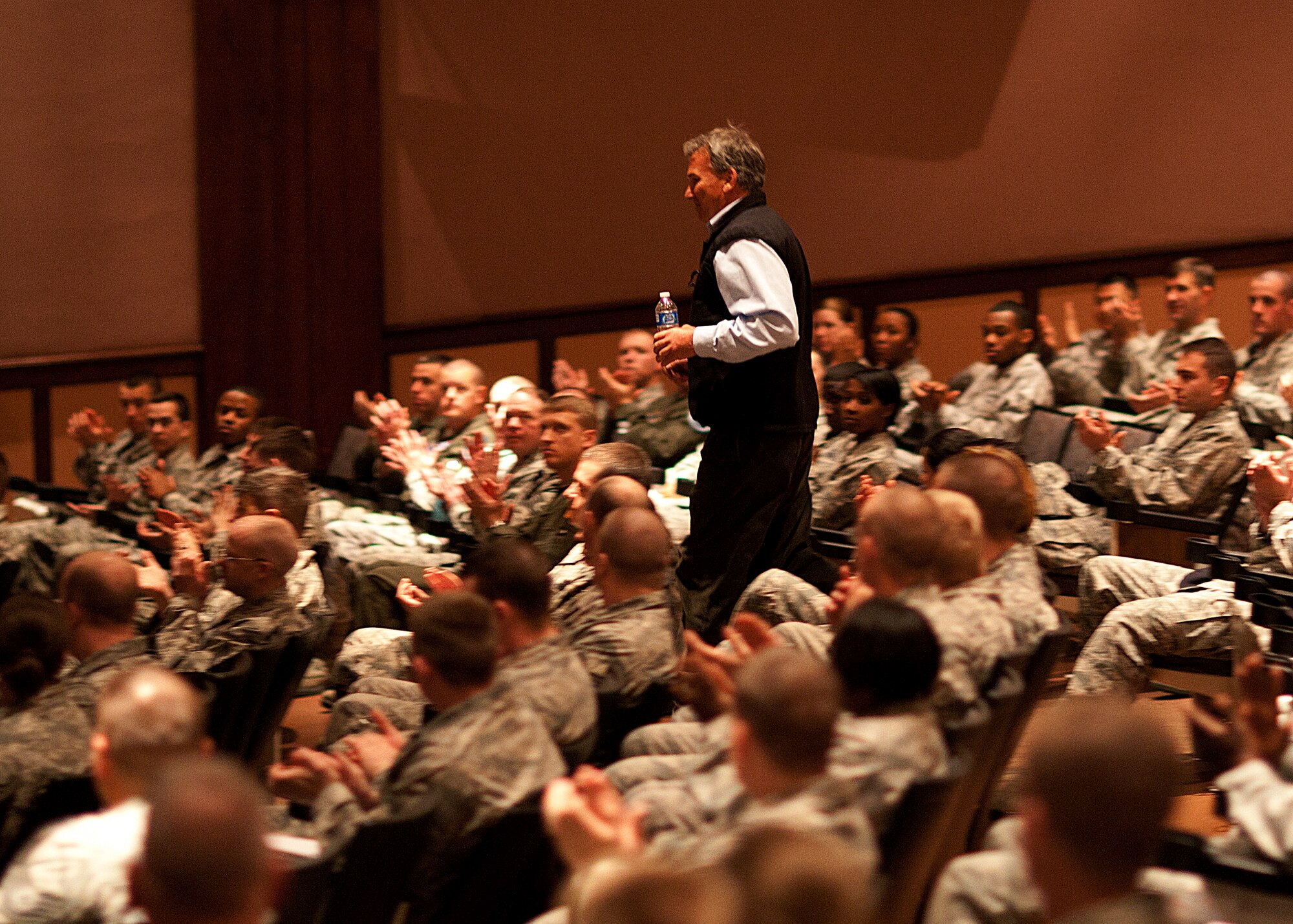 Tom Whittaker, the first amputee to Summit Mt. Everest, receives a warm reception as he makes his way to the stage of the Base Theatre March 23. Whittaker spoke to the troops as part of the American300 tour which was established to help connect great Americans with troops serving in harm's way in remote and isolated areas of operation around the world. (U.S. Air Force photo by Matt Bilden)