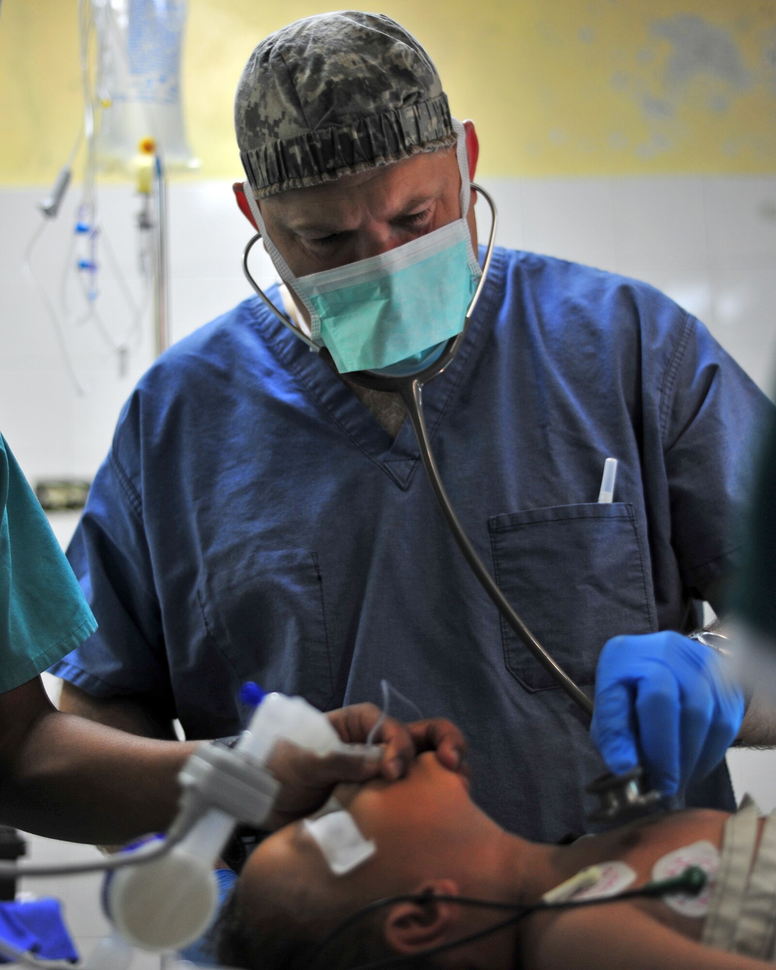 SOTO CANO AB, Honduras -- Army Maj. James Eads, Mobile Surgical Team nurse anesthetist, checks a Honduran boy's vitals after receiving anesthesia from the Honduran medical provider, prior to his operation by the MST from Joint Task Force-Bravo, Soto Cano AB March 15 at the Santa Teresa Hospital in Comayagua, Honduras. Recently, the mobile surgical team mobilized and established an assembly area to the local hospital in Comayagua during the Comayagua prison fire and was available to provide assistance as needed. The next week, the team performed follow-on surgical procedures on prisoners needing irrigation and debridement of burns. (U.S. Air Force photo/Staff Sgt. Bryan Franks) 