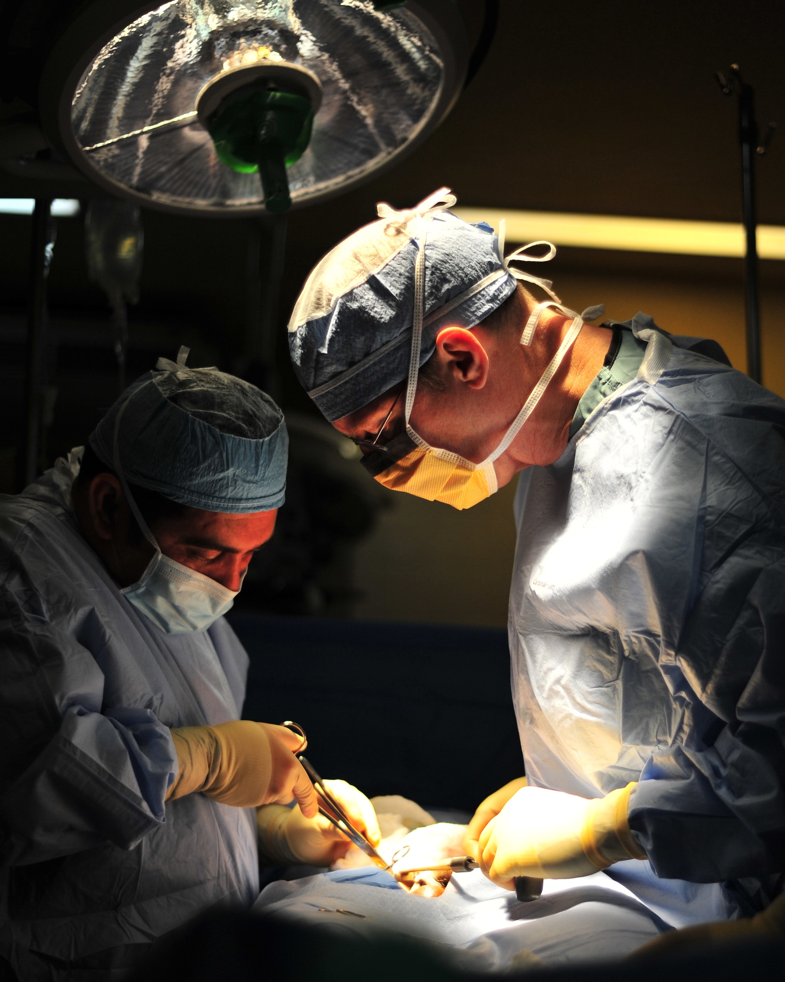 SOTO CANO AB, Honduras -- Honduran Dr. Jose Mejia and Army Col. George Peoples, Mobile Surgical Team surgeon, work together to perform surgery on a Honduran boy March 15 at Santa Teresa Hospital in Comayagua, Honduras. The seven-member mobile surgical team travels around Honduras to provide medical assistance to hospitals as a part of their medical readiness and training exercises. (U.S. Air Force photo/Staff Sgt. Bryan Franks)