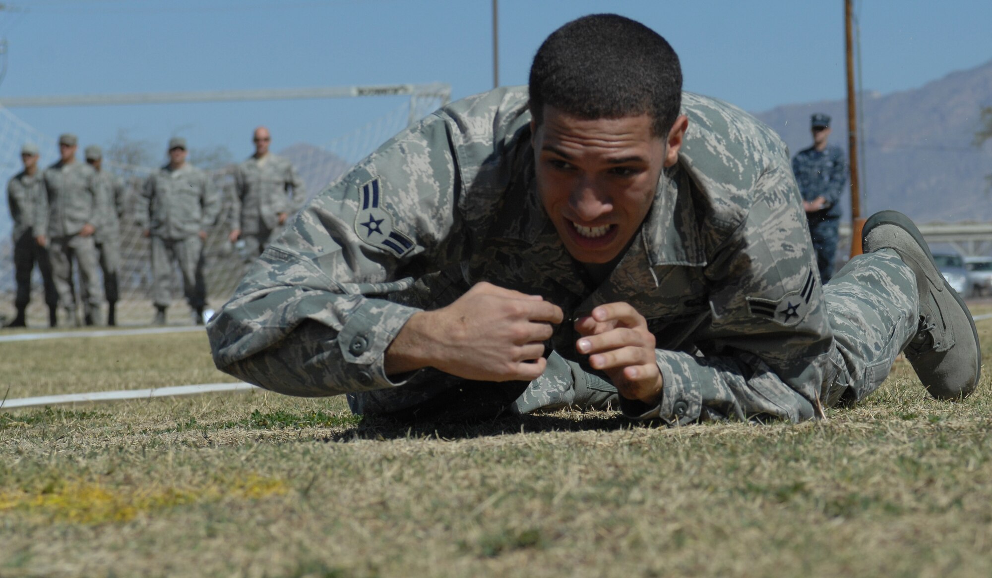 U.S. Air Force Airman 1st Class Corinthain Maldonado, 355th Communications Squadron, low crawls during the obstacle course portion of the Marine Challenge at the Benko Fitness Center track on Davis-Monthan Air Force Base, Ariz., March 23. Participants were required to complete the U.S. Marine Corps Maneuver Under Fire course. (U.S. Air Force photo by Airman 1st Class Saphfire Cook/Released)