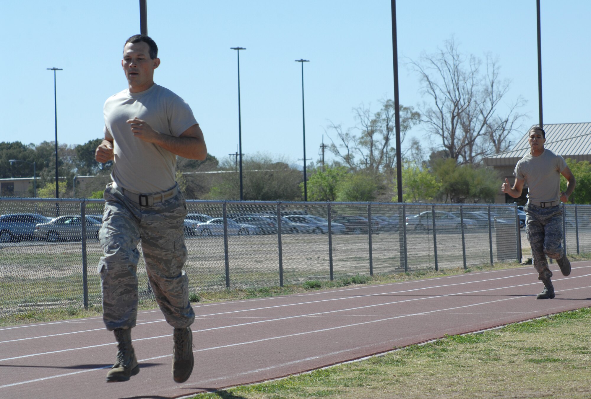 U.S. Air Force Master Sgt. Kevin Shaver, 355th Civil Engineer Squadron, and Airman 1st Class Corinthain Maldonado, 355th Communications Squadron, run the track portion of the Marine Challenge at the Benko Fitness Center track on Davis-Monthan Air Force Base, Ariz., March 23. Participants ran half a mile in uniform during the competition. (U.S. Air Force photo by Airman 1st Class Saphfire Cook/Released)