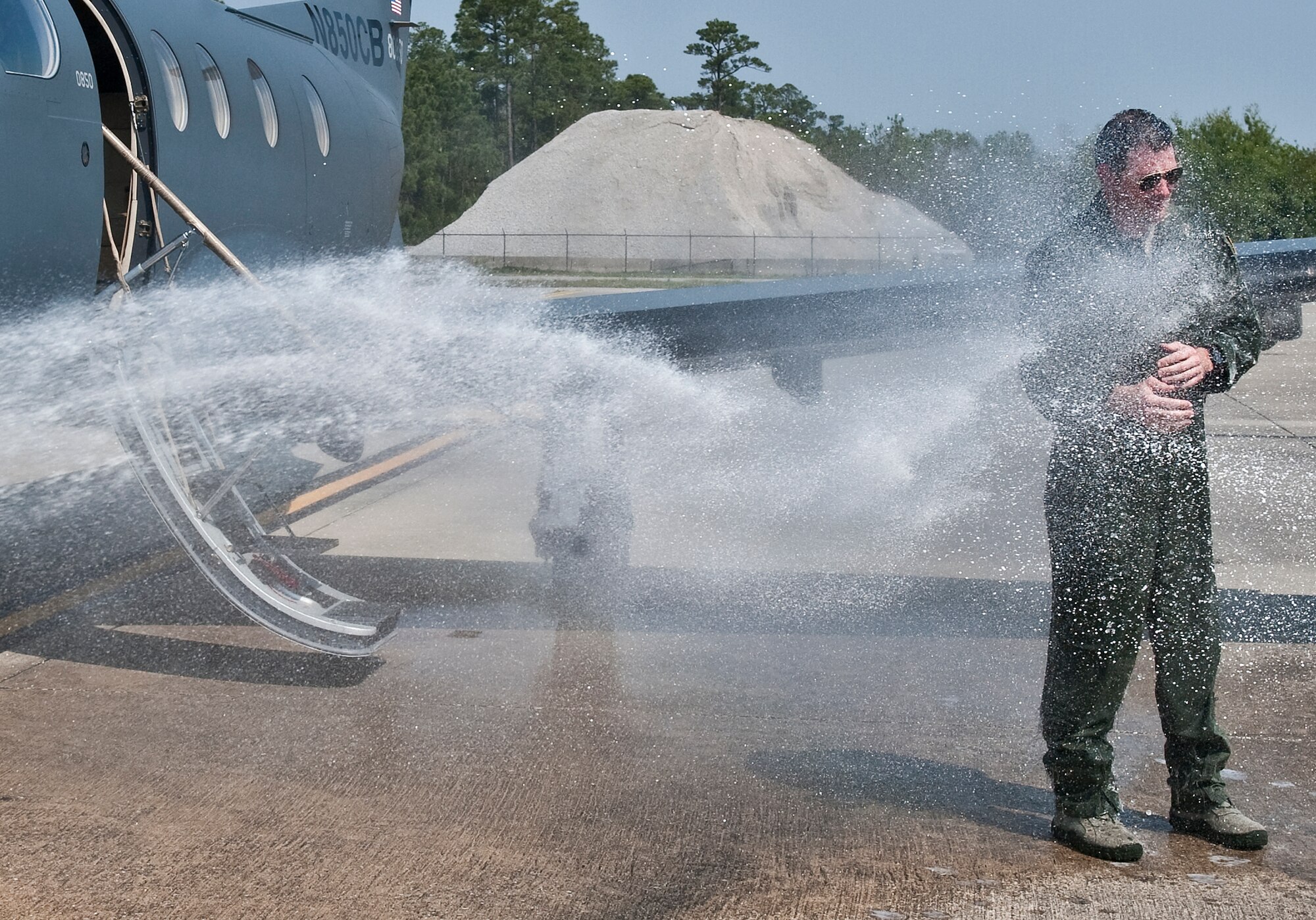 U.S. Air Force Lt. Col. Jeffrey P. Neely, director of operations at 319th Special Operations Squadron, gets sprayed down as part of a tradition during the final flight of a pilot at the flight line on Hurlburt Field, Fla., March 27, 2012. Neely will retire March 30, 2012 after 21 years of service. (U.S. Air Force photo/Airman 1st Class Christopher Williams)(Released)
