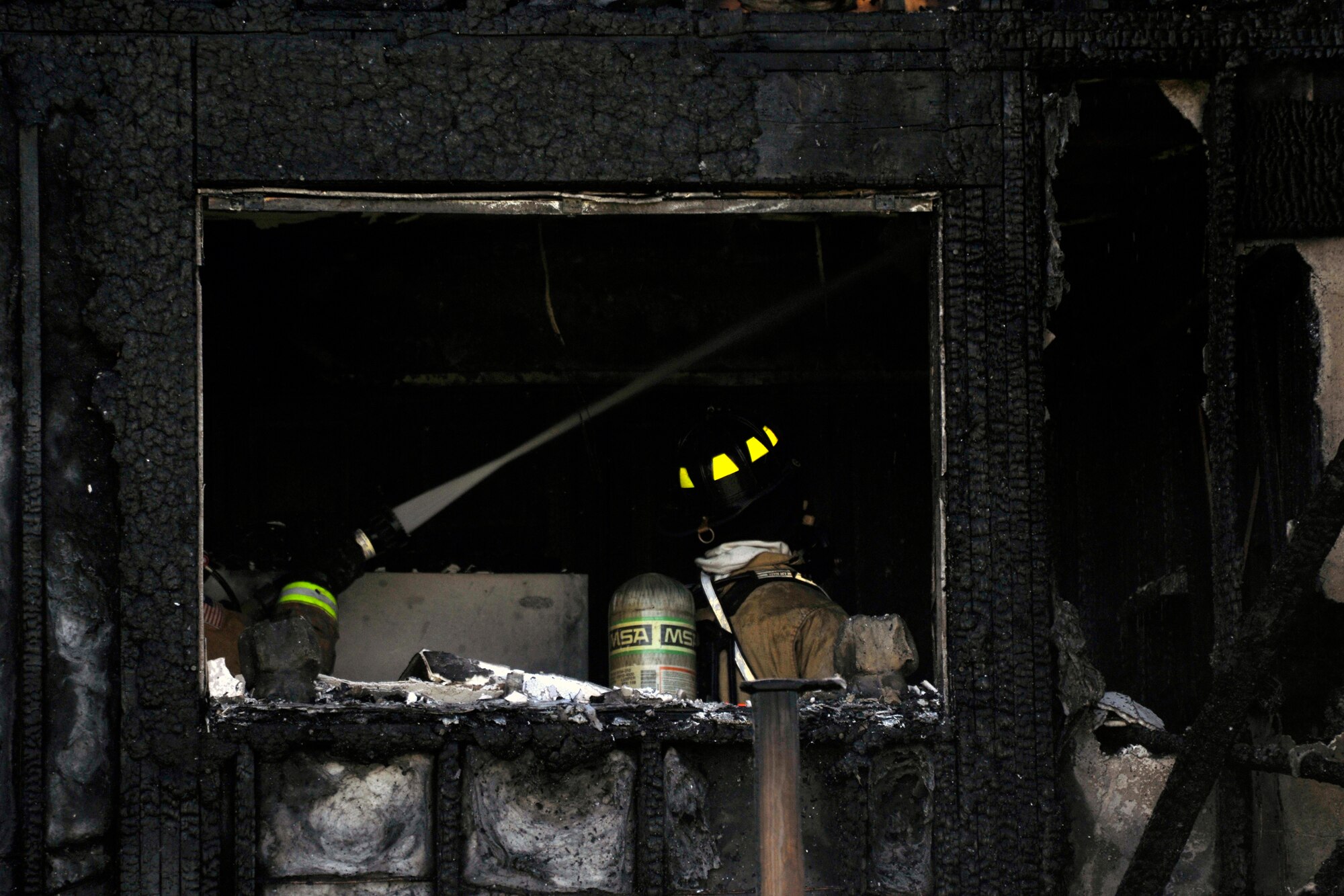 11th Civil Engineer Squadron and Prince George’s County firefighters search for house embers that could reignite flames March 29. Firefighters from the 11 CES and two stations in Prince George’s County fought the flames that ended up damaging multiple homes. (U.S. Air Force photo/Senior Airman Perry Aston)