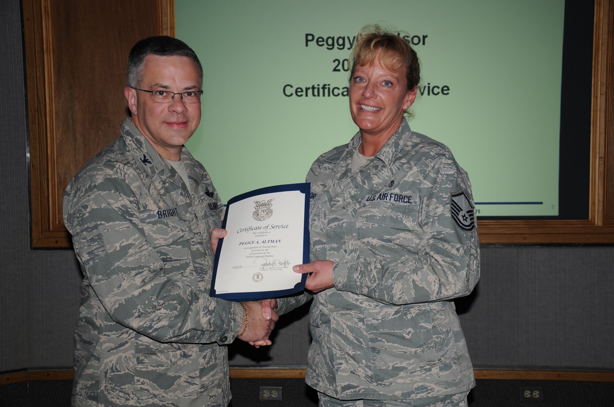 Col. Randal L. Bright, 512th Airlift Wing commander, presents Master Sgt. Peggy Windsor, 512th Aerospace Medicine Squadron, with a pin and certificate in recognition of her 20 years of service to the Air Force. Windsor is an Air Reserve Technician. She works as civil service employee during the week in the same job she holds as a reservist on unit training assembly weekends. ARTs are the full-time backbone of the unit training program, providing day-to-day leadership, administrative and logistical support, and operational continuity for their units. More than 15 percent of all reservists are ARTs. (U.S. Air Force photo by Capt. Marnee A.C. Losurdo)