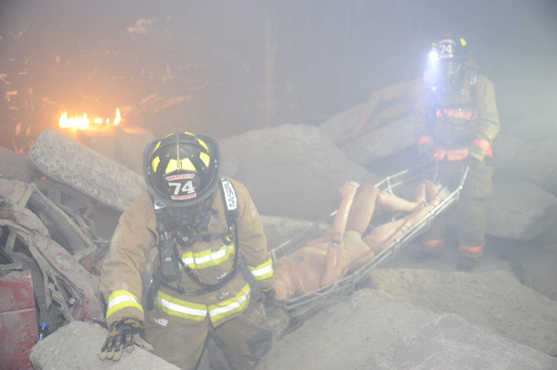11th Civil Engineer Squadron Firefighters transport a dummy victim away to from danger March 28 during the Air Force District of Washington Black Flag Exercise held at the Center for National Response in Gallagher W.Va. This is the fifth year the annual AFDW Black Flag exercise at the Center for National Response in W.Va. has been held to prepare Airmen for real world disasters from chemical, biological, radiological, and nuclear incidents or attacks. (U.S. Air Force photo by Staff Sgt. Christopher Ruano)