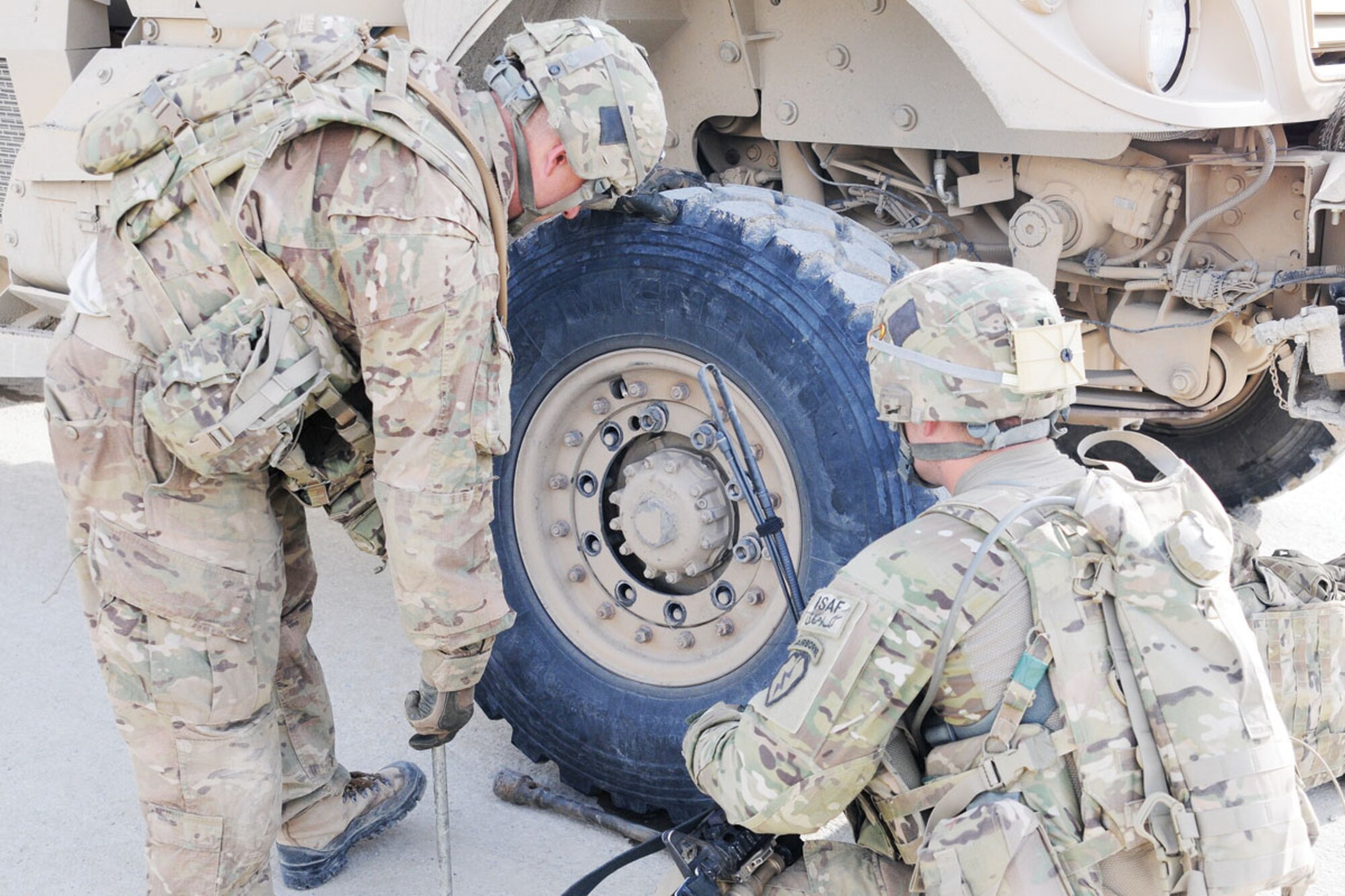 Paratroopers with 1st Platoon, Comanche Company, Task Force Blue Geronimo, fix the tire on their Mine-Resistant Ambush-Protected vehicle while on a three-day mission.  (U.S. Army photos/Spc. Erik-James Estrada)
